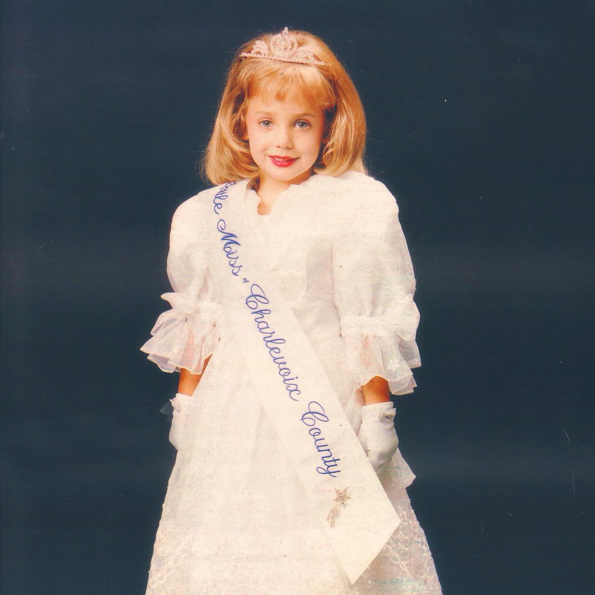 And last but certainly not least, JonBenét’s first-ever Pageant title.Crowned in the Summer of 95 in the rural, lakeside community of Charlevoix MI. A tiny bejeweled tiara sits askew atop JonBenét’s mop of blond hair.She’d be the first, last and *only* Little Miss Charlevoix.