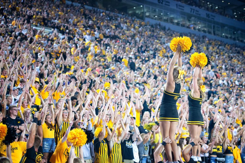 Iowa cheerleaders lead a crowd of Hawkeye fans as they chant during an Iowa footb...