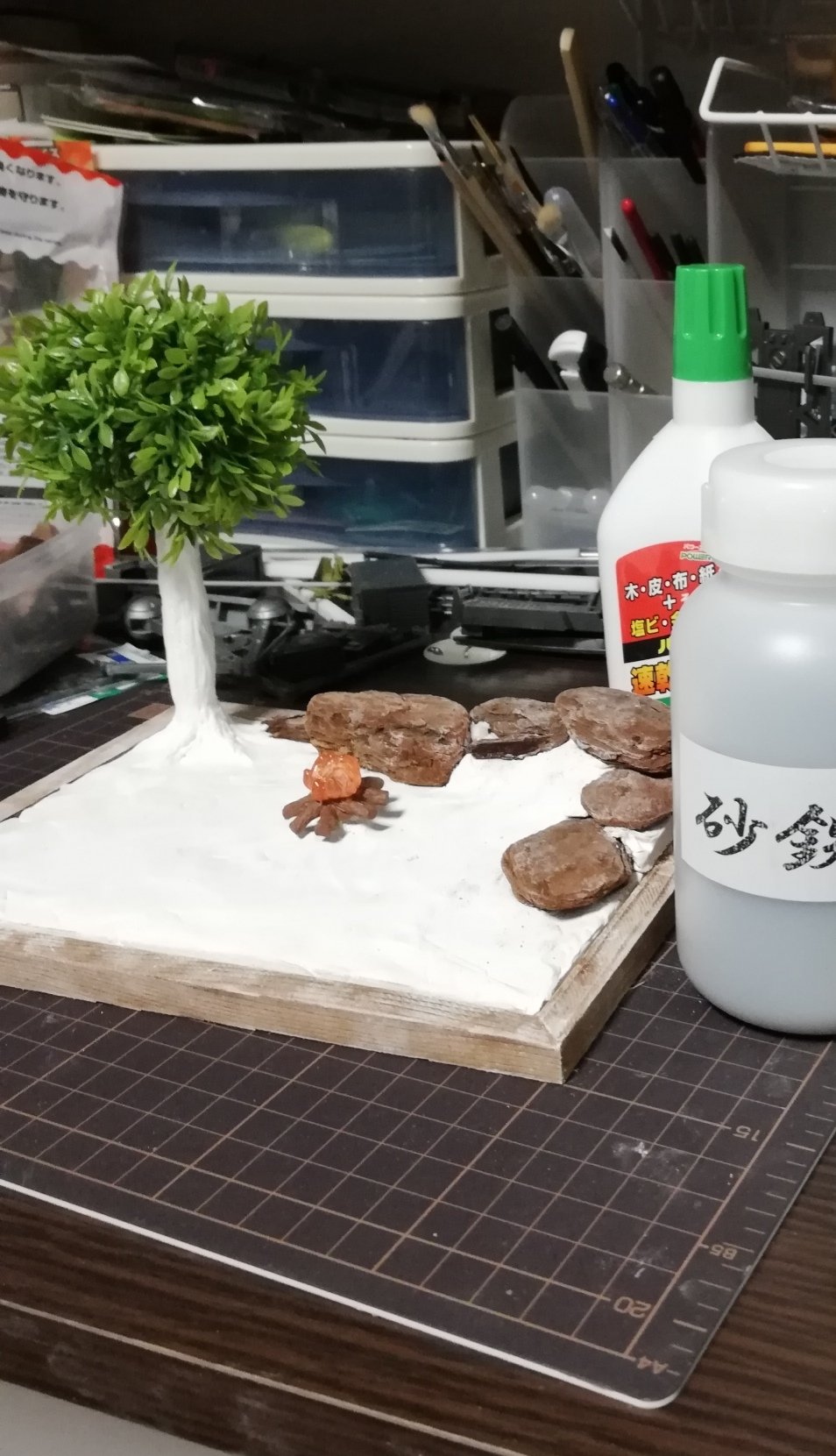 Tori 撮影用100均森です 箱庭技研ジオラマシートを背景に100均の人工芝を敷き造花を設置 中央プチジオラマは紙粘土 インテリアバーク 造花で形作り 電飾埋めて食玩キャンプファイア設置 そして砂鉄を水溶きボンドで接着後に100均アクリルで塗装
