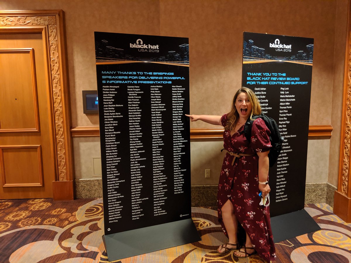 A smiling Maddie pointing to my name on the Blackhat speakers list