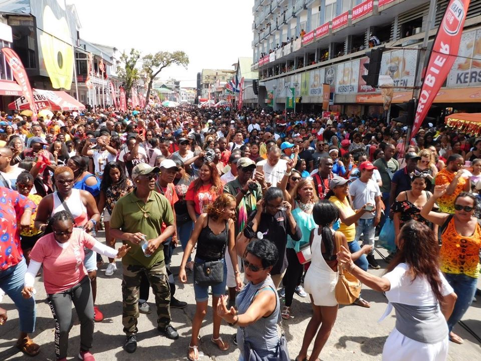 SurinameMirror's tweet photo. #OwruYari #Pagara Estafette trekt weer veel publiek in centrum #Paramaribo - Festijn om te zien en gezien te worden.... - #Suriname) -  Veel mensen waren met hun eigen voorraad (sterke) drank gekomen #ongezond #vuurwerk https://t.co/F07Y4aaO7r https://t.co/EIEgHGlC6C