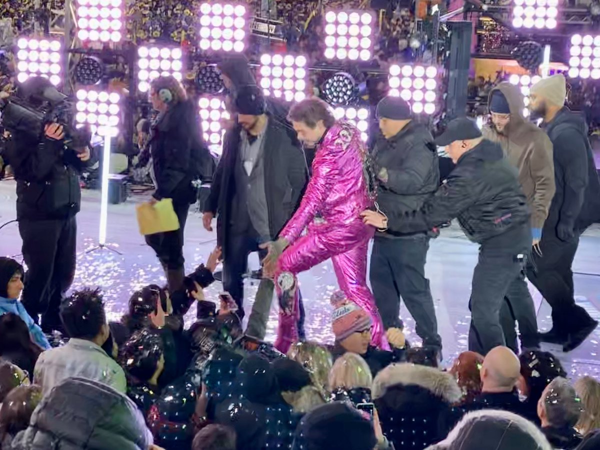 ChrisPollone's tweet photo. Here’s the aftermath of Post Malone falling off the stage tonight. He had just hugged Seacrest and went to shake fans’ hands and his foot slipped off the stage. After he and fans got over the initial shock he smiled for a selfie as roadies helped him back up. #nyc #nye https://t.co/mTt50qd2gd