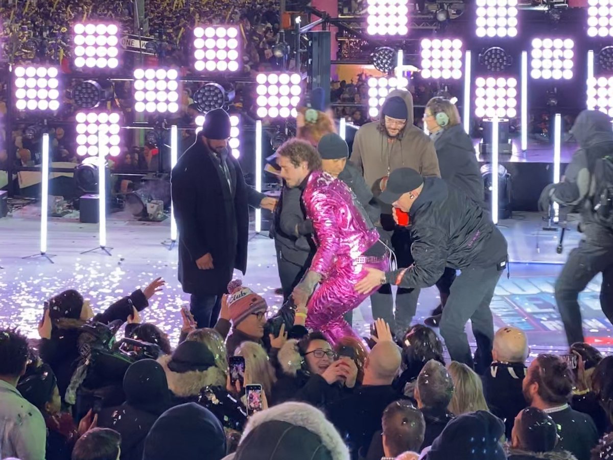 ChrisPollone's tweet photo. Here’s the aftermath of Post Malone falling off the stage tonight. He had just hugged Seacrest and went to shake fans’ hands and his foot slipped off the stage. After he and fans got over the initial shock he smiled for a selfie as roadies helped him back up. #nyc #nye https://t.co/mTt50qd2gd