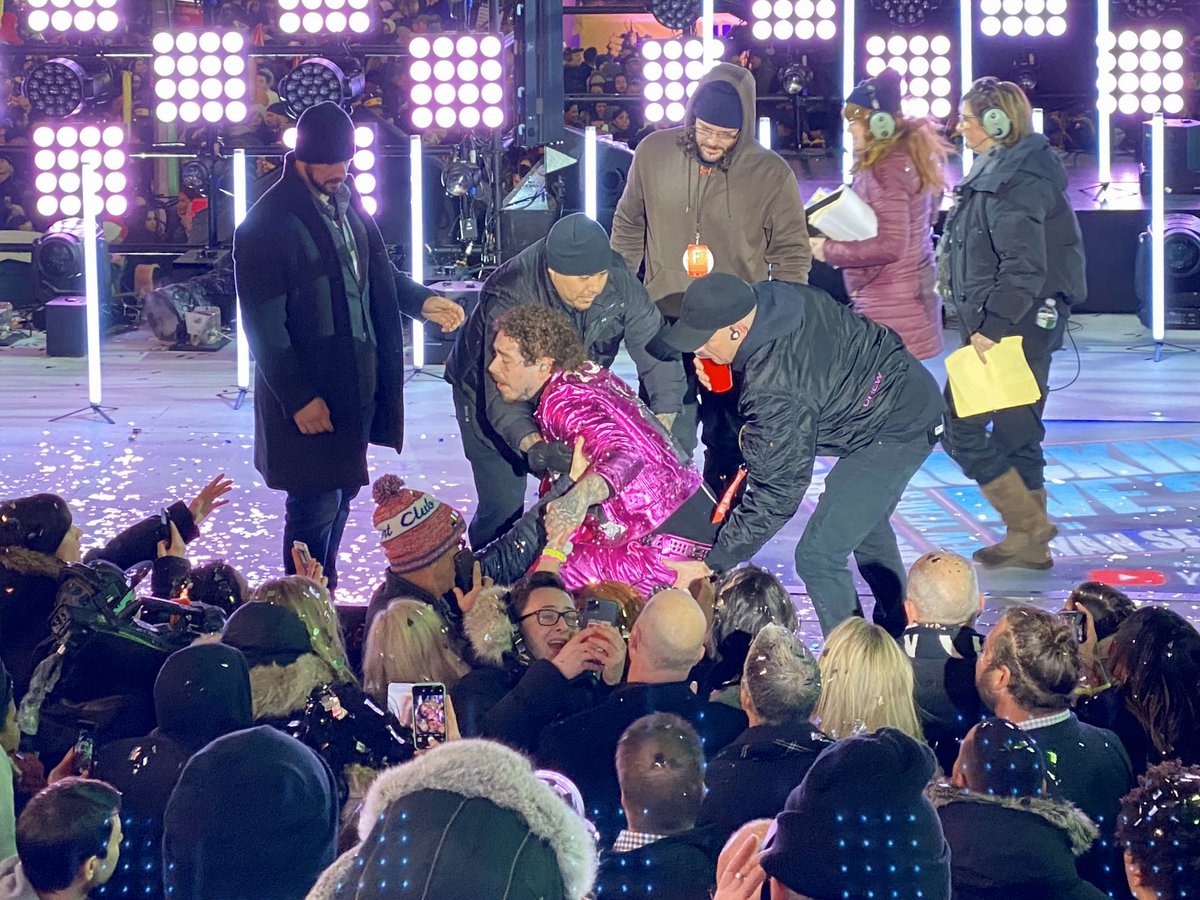 ChrisPollone's tweet photo. Here’s the aftermath of Post Malone falling off the stage tonight. He had just hugged Seacrest and went to shake fans’ hands and his foot slipped off the stage. After he and fans got over the initial shock he smiled for a selfie as roadies helped him back up. #nyc #nye https://t.co/mTt50qd2gd
