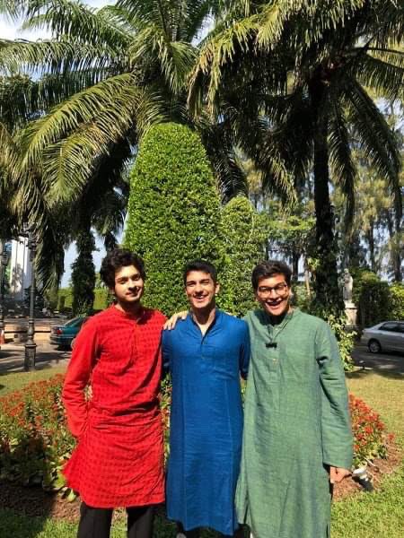 DJ, Ishaan and Chaitanya pictured in front of a palm tree in Thailand WUDC.