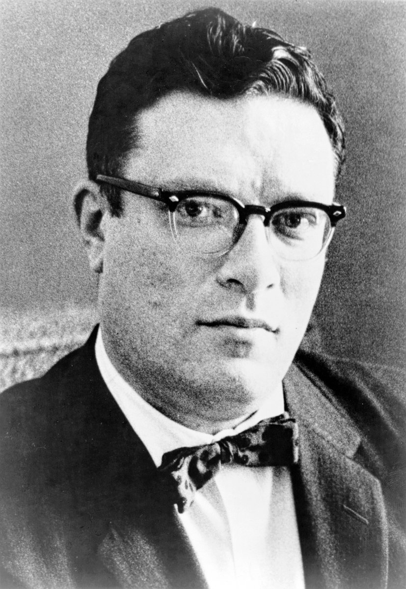 Black-and-white portrait of Isaac Asimov. He's looking the camera head-on. He has short hair and is is wearing glasses and a suit with a bowtie. 