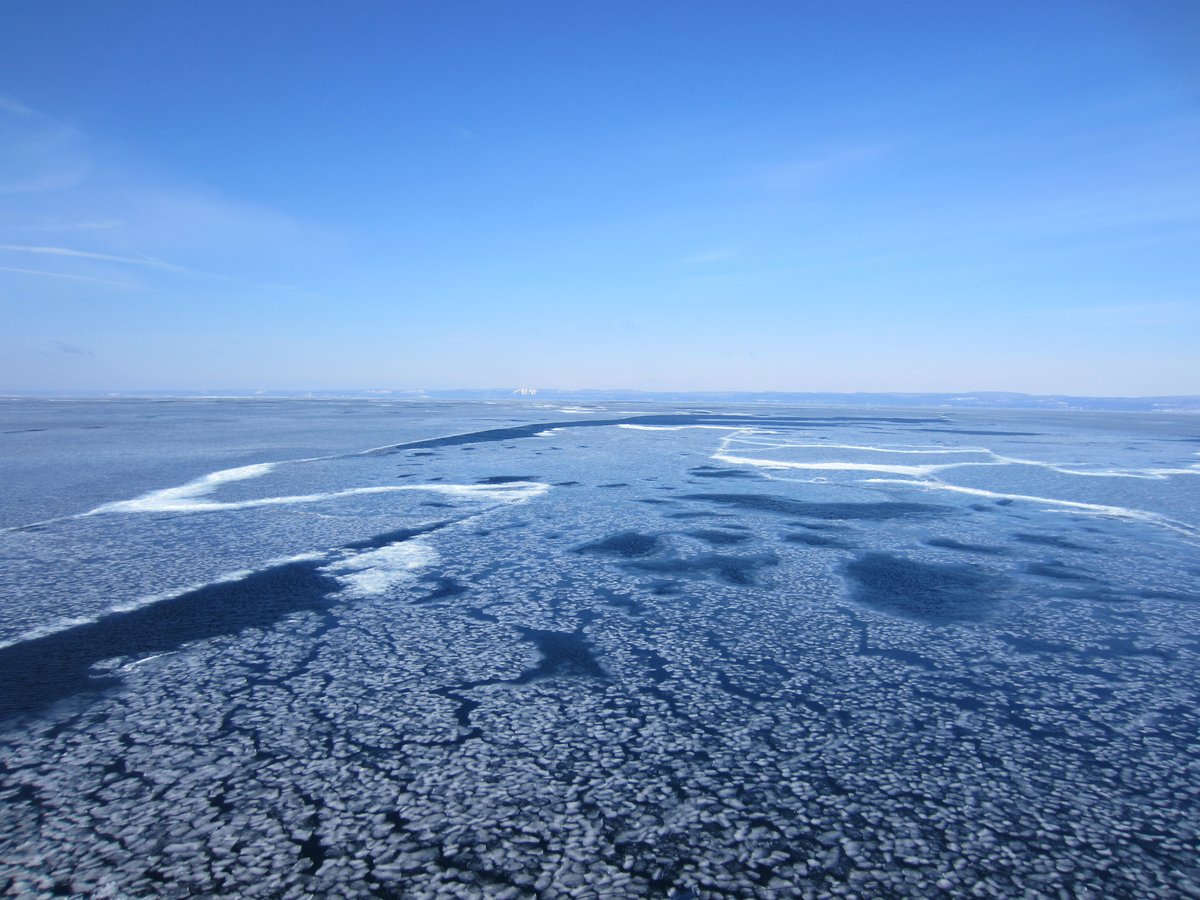 Small pieces of ice float in Lake Superior under a clear blue sky
