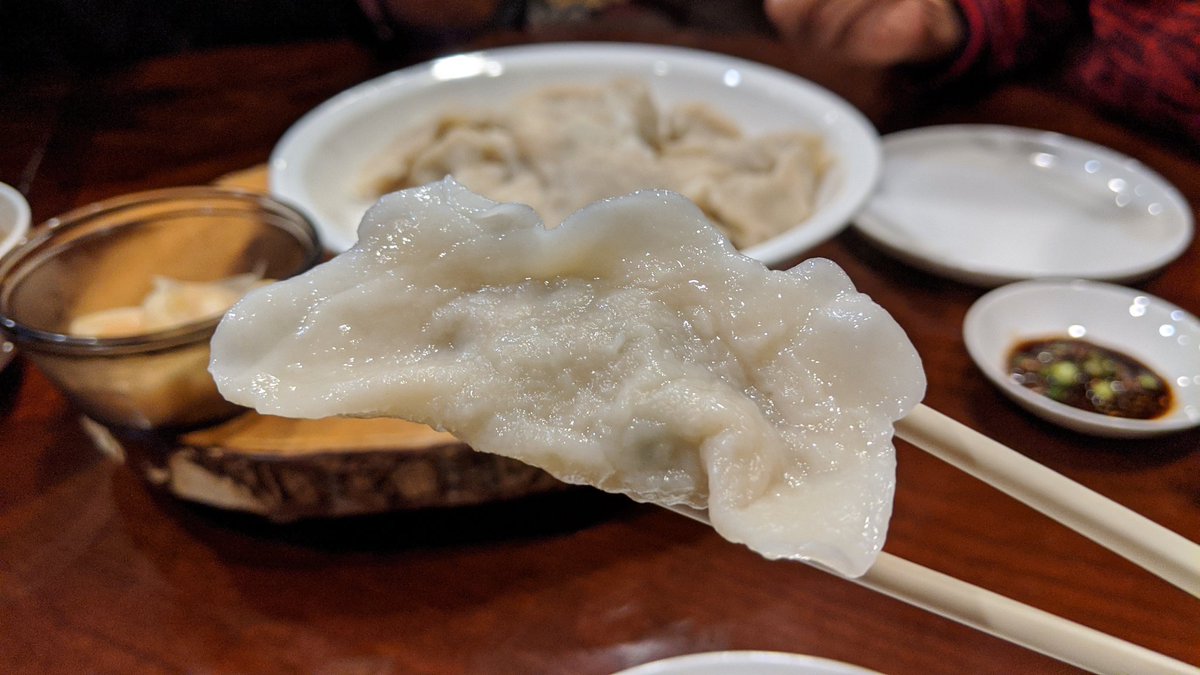 Closeup of a cooked dumpling using chopsticks