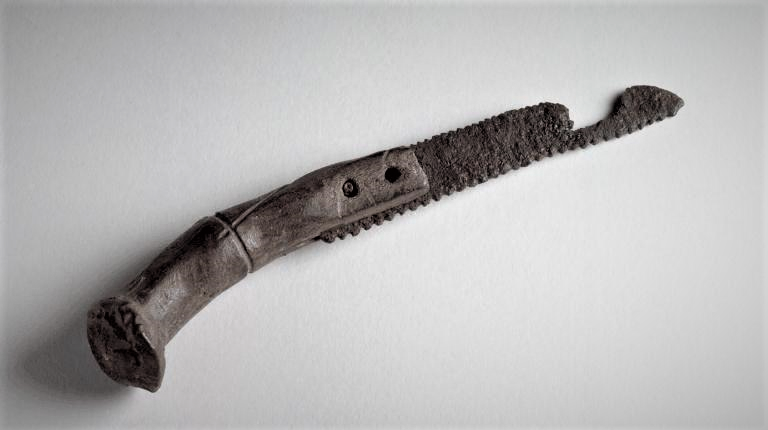 TrimontiumTrust's tweet photo. A #Roman saw found at #Trimontium (Newstead) in the #ScottishBorders, #Scotland. It has been dated to AD80-100 and was found in excellent condition. The saw is hafted into a split antler handle, held firm by two metal rivets &amp; the blade has both fine and coarse teeth. https://t.co/73W2DXZ11I