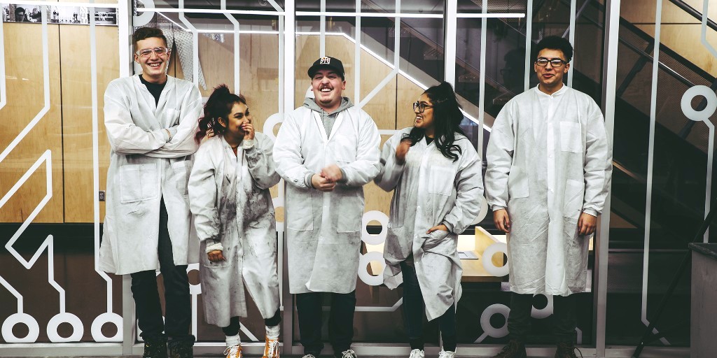 Students wearing lab coats laughing. Property of SLCC