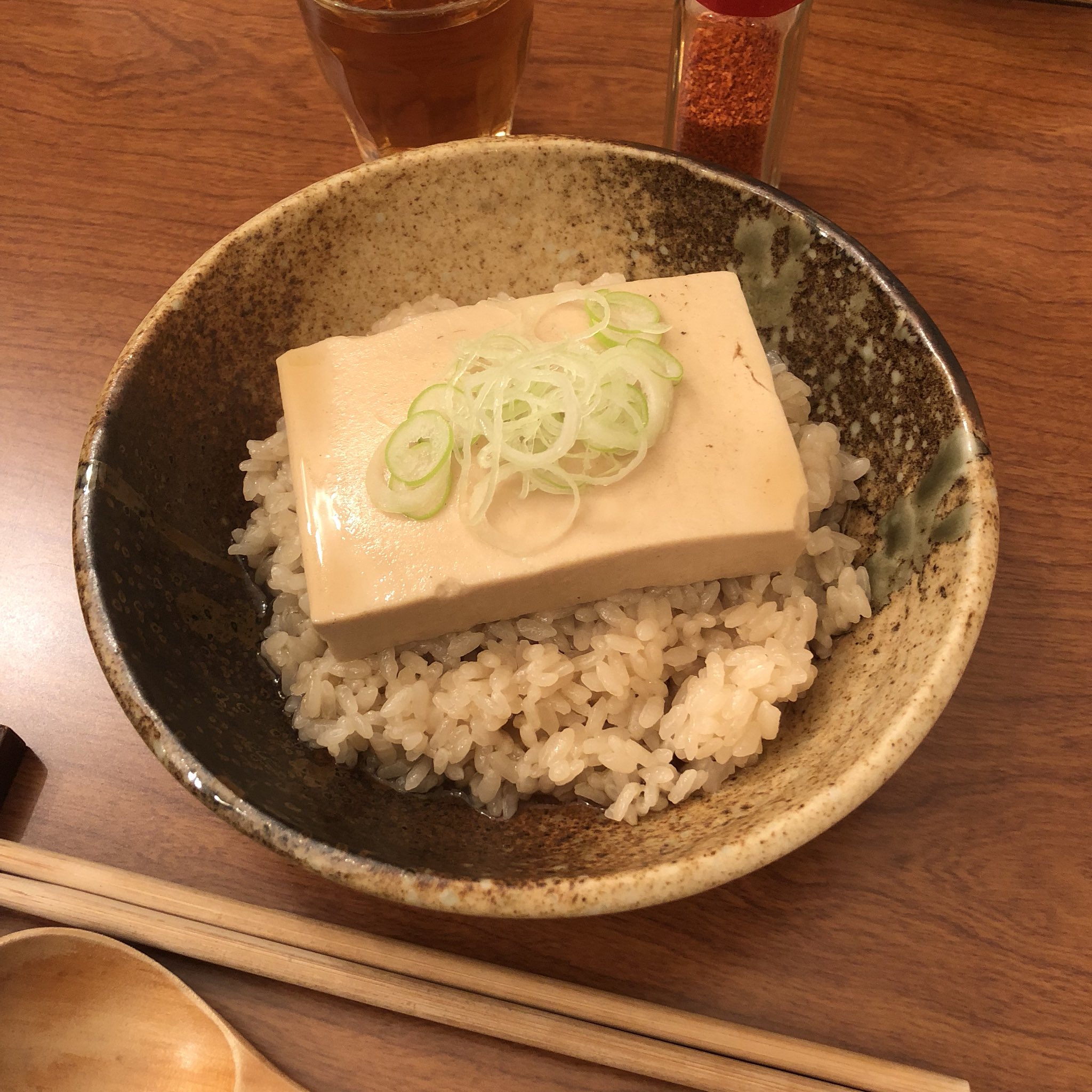 戌一 いぬいち おでんの出汁で絹ごし豆腐を煮て ほうじ茶でかために炊いた茶飯に乗せ おでんの出汁をかけネギを散らした 豆腐茶飯 かなり身体が温まる 一味をふると更にポカポカに