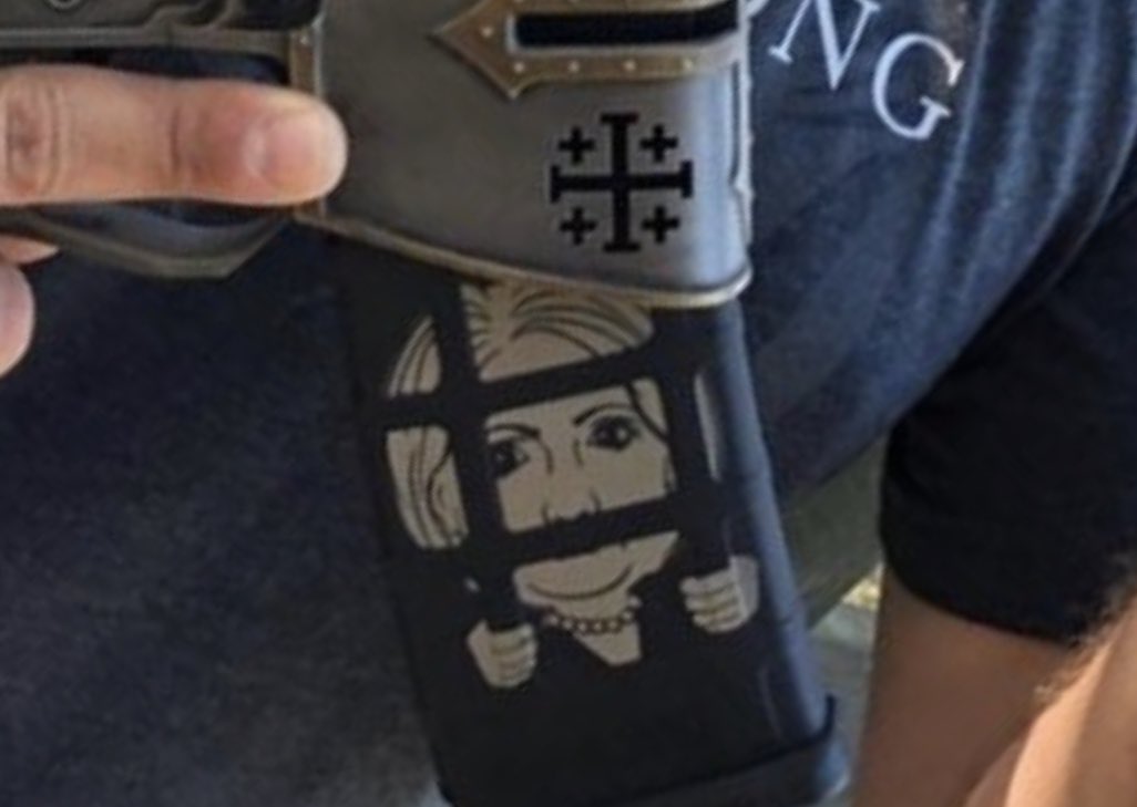 ScottLinnen's tweet image. It’s the impeached president’s namesake son with a gun. With a German Iron Cross. And a former political opponent behind bars on the magazine.