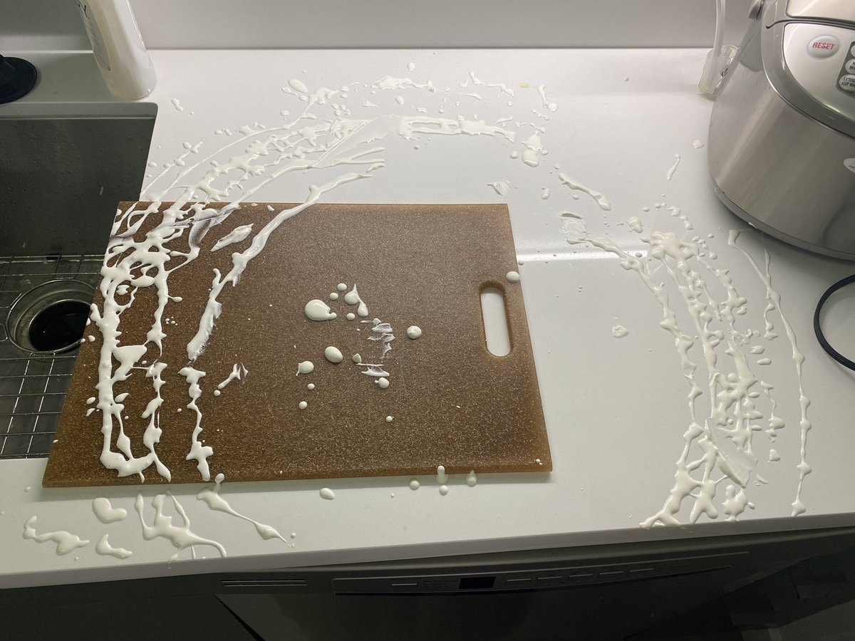 Concentric circles of sprayed whipped cream on a countertop and cutting board.