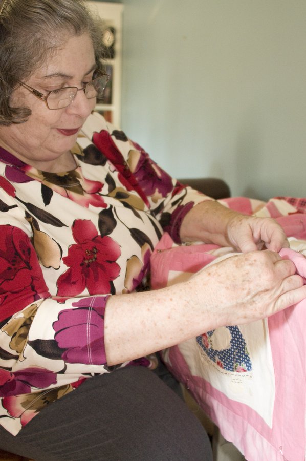 Imagen: Una mujer con artritis cosiendo un edredón.