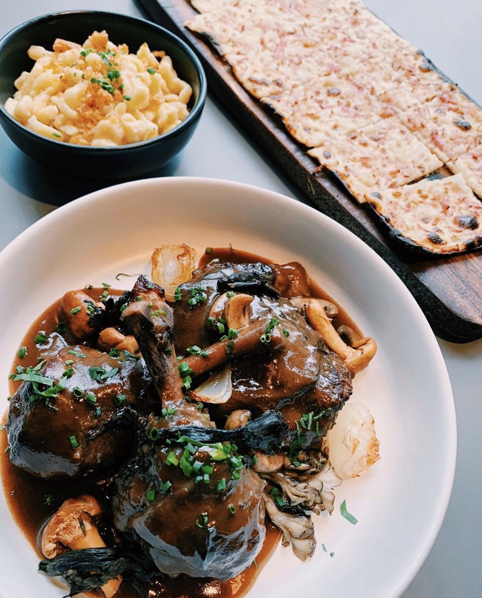 Snapshot of a perfect order at Faubourg: Alsatian Tarte Flambée with fromage blanc and bacon, Coq Au Vin with Spaetzle, and - not pictured - a glass of Châteauneuf-du-Pape 💯