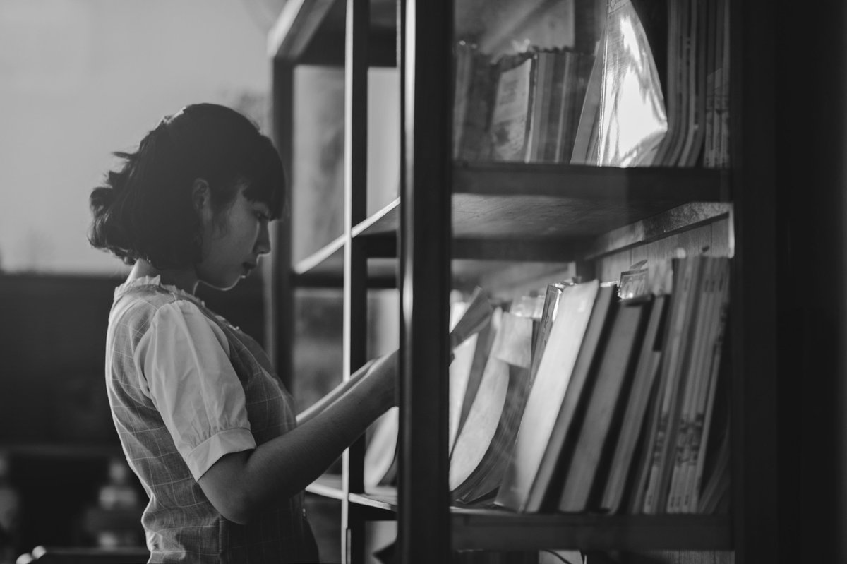 Young Asian woman consulting a large format library book.