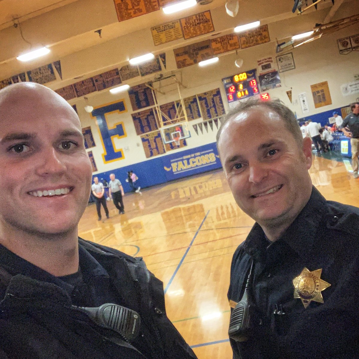 pleasantonpd's tweet photo. Check it out! Ofc. Matt Harvey and Ofc. Mike Rossillon are at tonight’s basketball game and ready to support our #FoothillFalcons! Fun fact: Ofc. Harvey graduated from #Foothill in 2012. 👨‍🎓 #GoFoothill https://t.co/vRTqpiVy9P