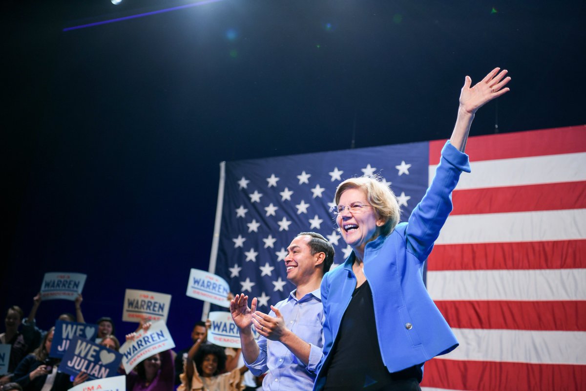 Elizabeth Warren and Julián Castro wave to supporters.