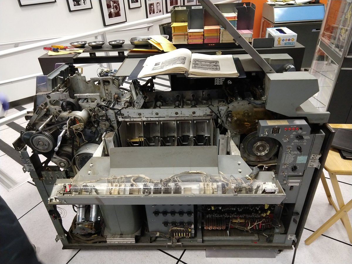 The card reader/punch opened up with the front panel removed, showing the gears and mechanisms inside.