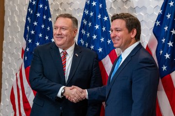 Secretary Pompeo shakes hands with Florida Governor DeSantis.