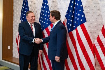 Secretary Pompeo shakes hands with Florida Governor DeSantis.