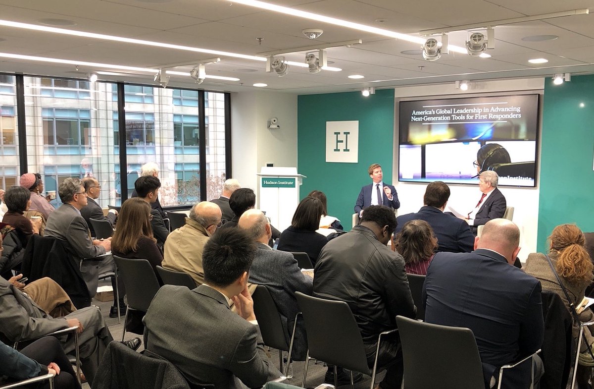 Edward Parkinson speaks to moderator in front of crowd at Hudson Institute