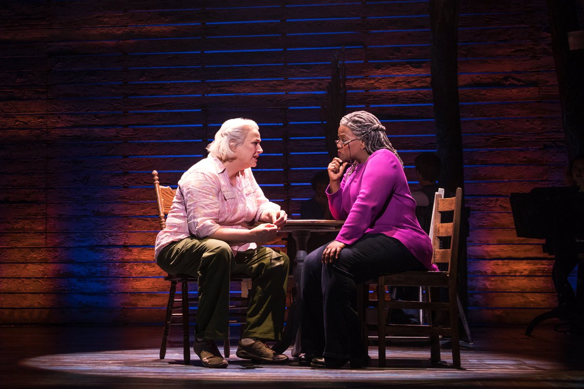 Hannah and Beulah sitting at a round wooden table on stage 