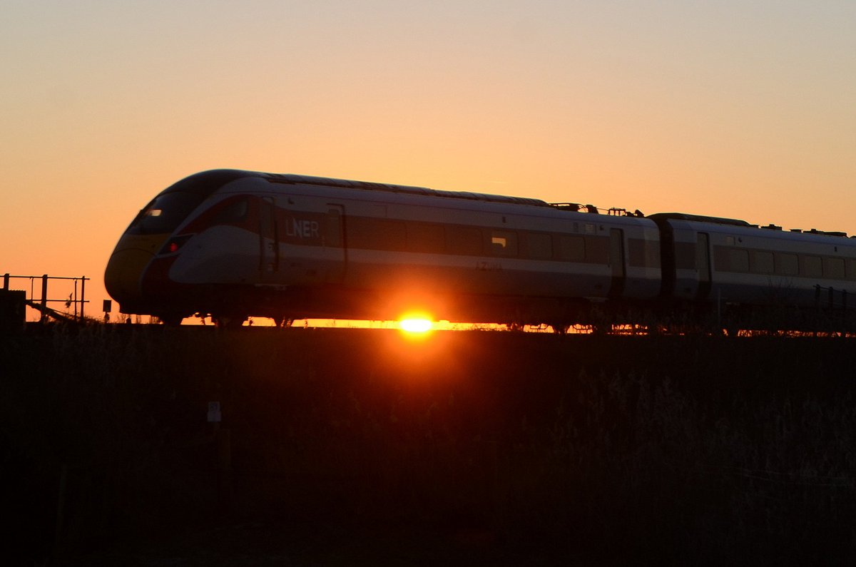 MrDeltic15's tweet photo. Then a short stop at #Turves where 800104 passes with the wind turbines and chimneys in the background, before finishing at #BeggarsBridge 800112 eastbound followed by "kissing" 800202 & 800208, with an unidentified 800 catching a lovely sunset @LNER @RailfutureEA @RailwaysToday https://t.co/711X3jvXmN