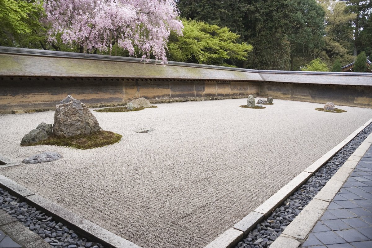 At Ryoan-Ji in Kyoto, only 14 of the 15 garden stones are visible at any one time — the effect is in the spaces between the stones, the absence that is always present, that we have to dwell in.