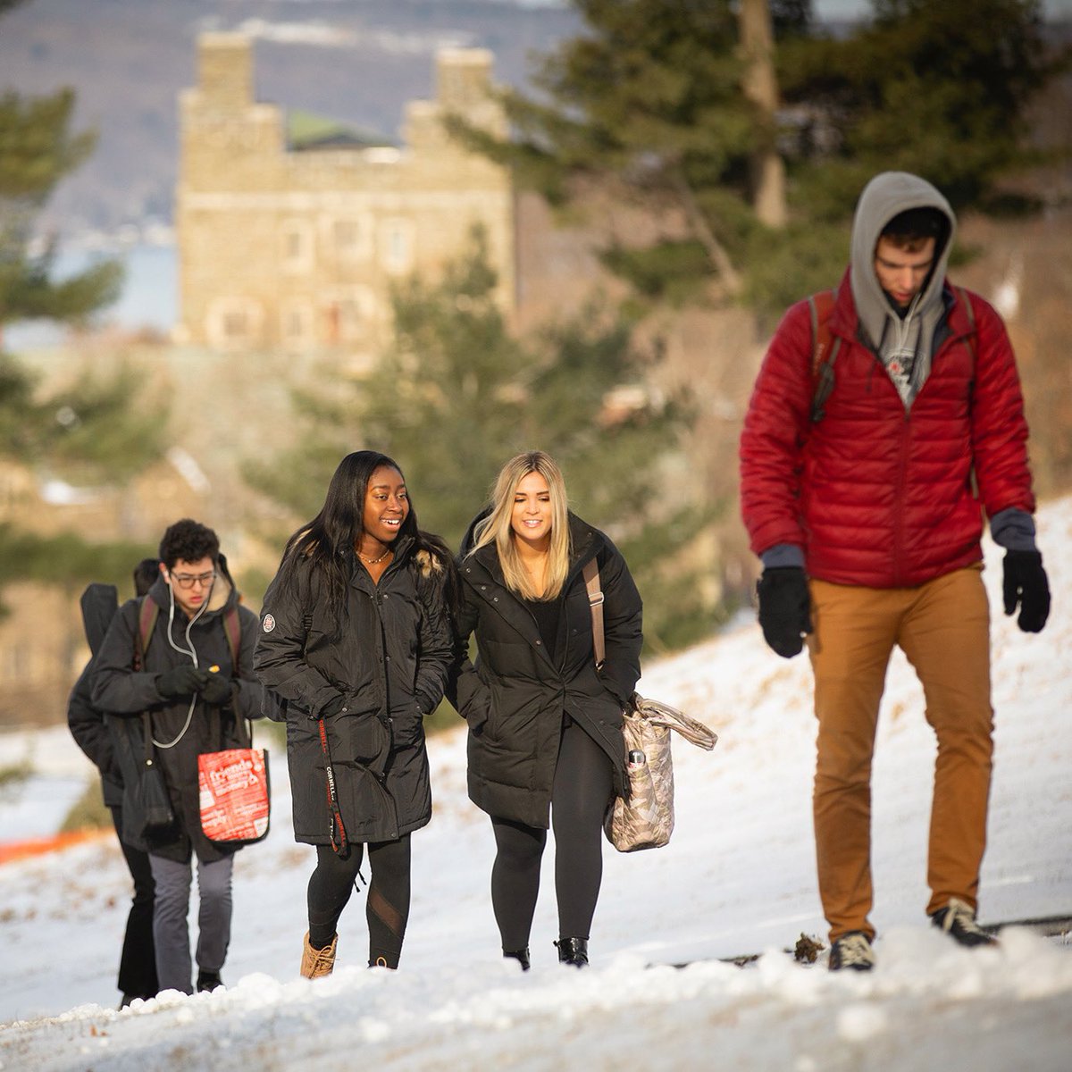 Students walk up a snowy slope on the way to classes at Cornel University