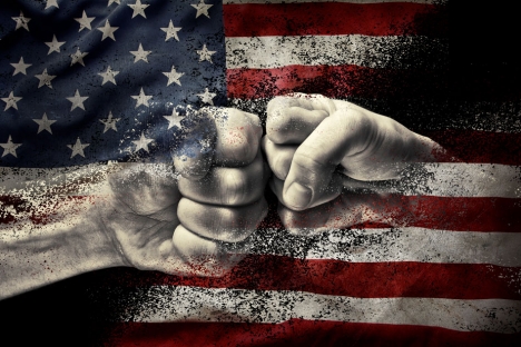 Two fists are bumping and they're blending into the background of the American flag.