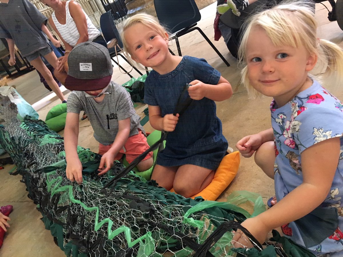 Children play and craft in Lincoln Cathedral. with big smiles on their happy faces.