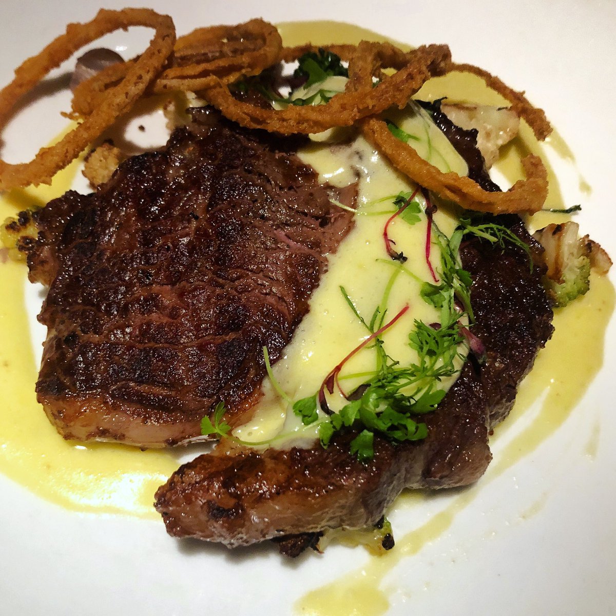 #Beef lovers, this one’s for you! For a limited time we’ve got a supplemental 10oz. New Zealand #ribeye on the menu! Served with #whitetruffle #béarnaise, sautéed cauliflower, broccolini and pearl onions, and don’t forget those crispy onion rings!!
