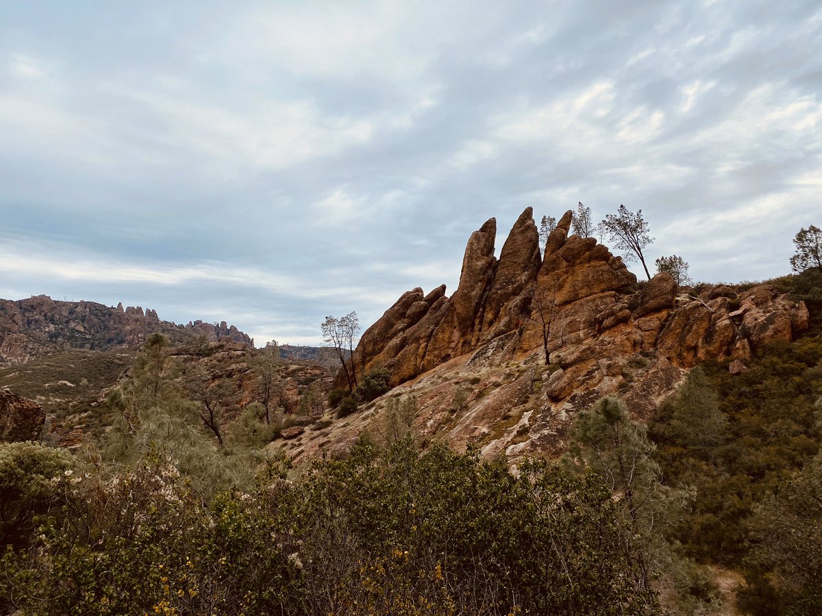 Red rocks in the distance jutting into a blue grey sky.