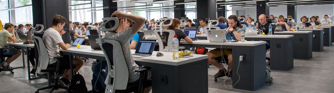 Office workers sitting at desks staring at screens