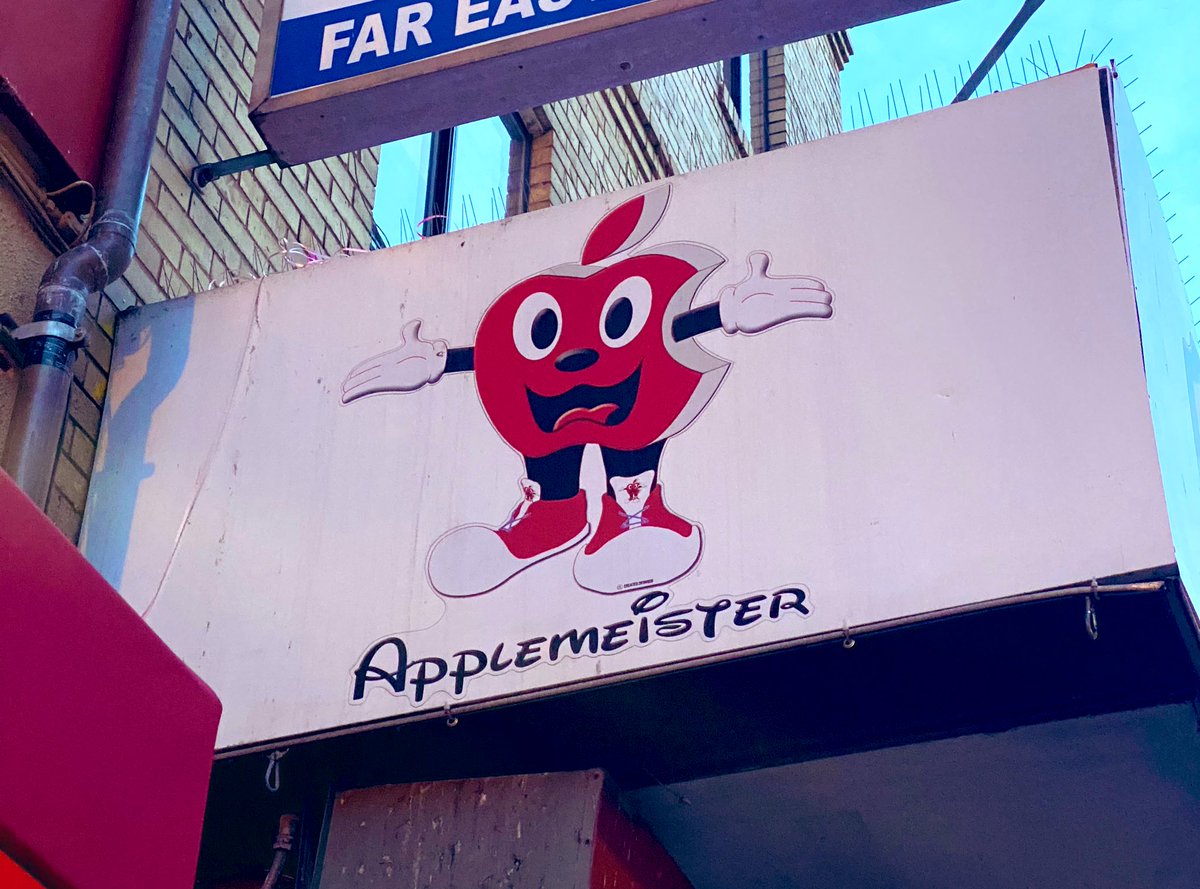 Photo of a shop sign. Shop is called Applemeister and it’s written in the Disney font. Sign had an Apple logo with arms and legs and a face, like if you crossed Mickey Mouse with a red Apple Logo.