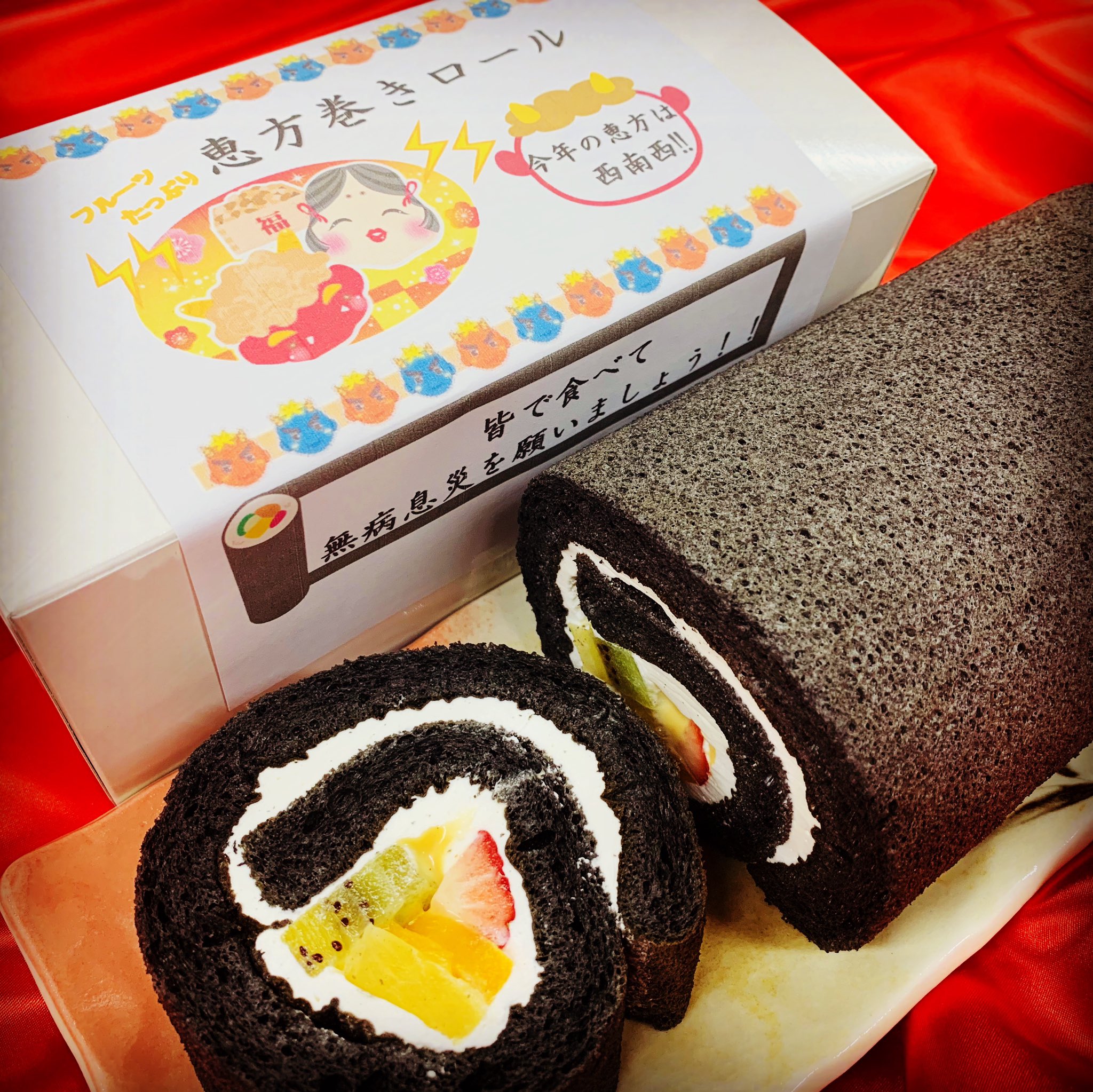 リスボン豊中店 恵方巻きロールのご紹介 黒い生地は美容にも良いとされている食用の竹炭パウダーを贅沢に使用 ふわふわのスポンジで北海道産の生クリームやフルーツ カスタードクリームを包み込んでいます 皆んなで食べて無病息災を願いましょう