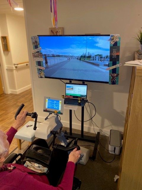 VidaHealthcare1's tweet photo. @VidaHealthcare1 recently invested into an incredible piece of equipment that allows residents to exercise daily from the comfort of their own home! 🚴‍♂️

Just look at the smile on our residents face as she enjoys pedaling down Bondi Beach on the motorised bike! ☀️ 

@Motitech_UK https://t.co/AtZIJLJoLw