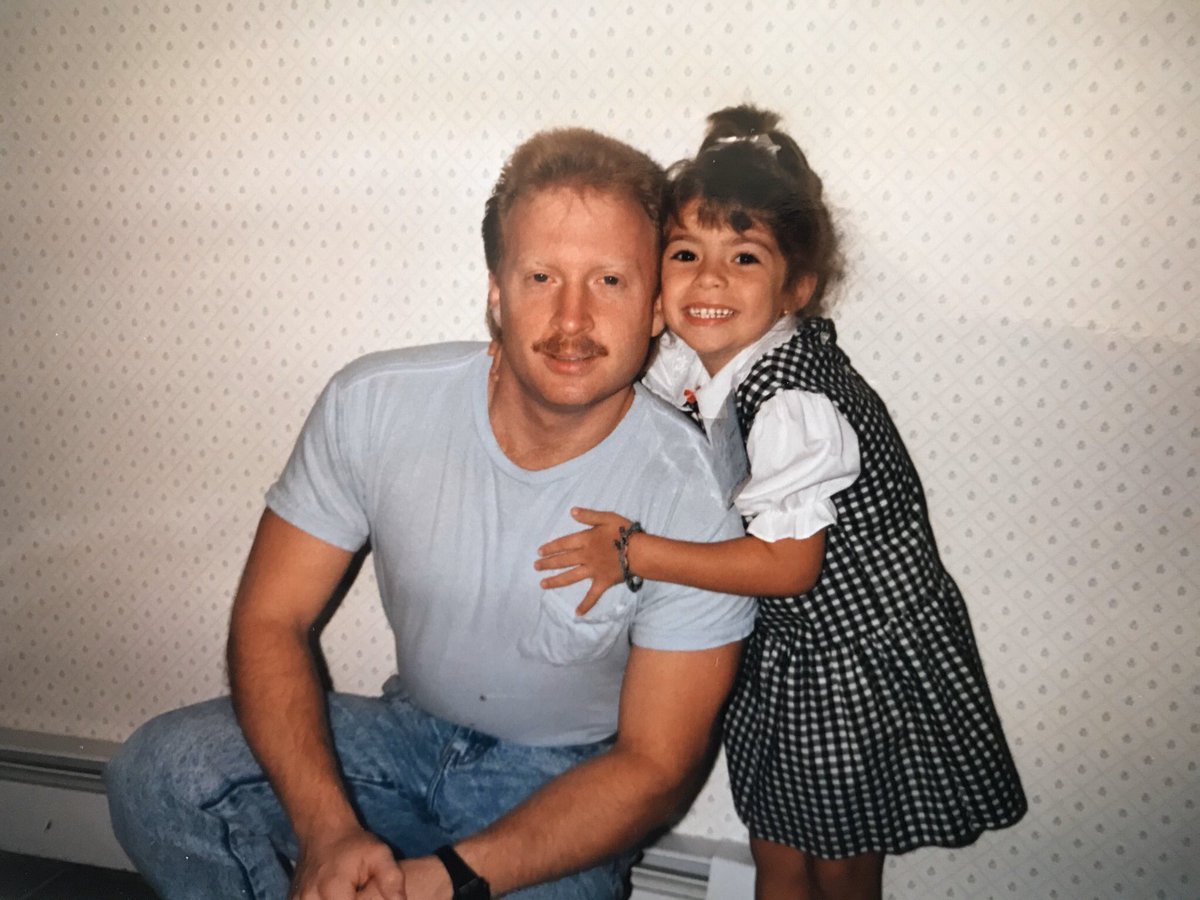 Picture of Jess as a 4 year old hugging her dad in their kitchen.