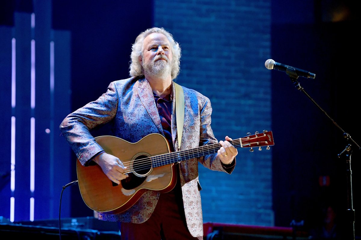 robert earl keen on stage playing the guitar and smiling