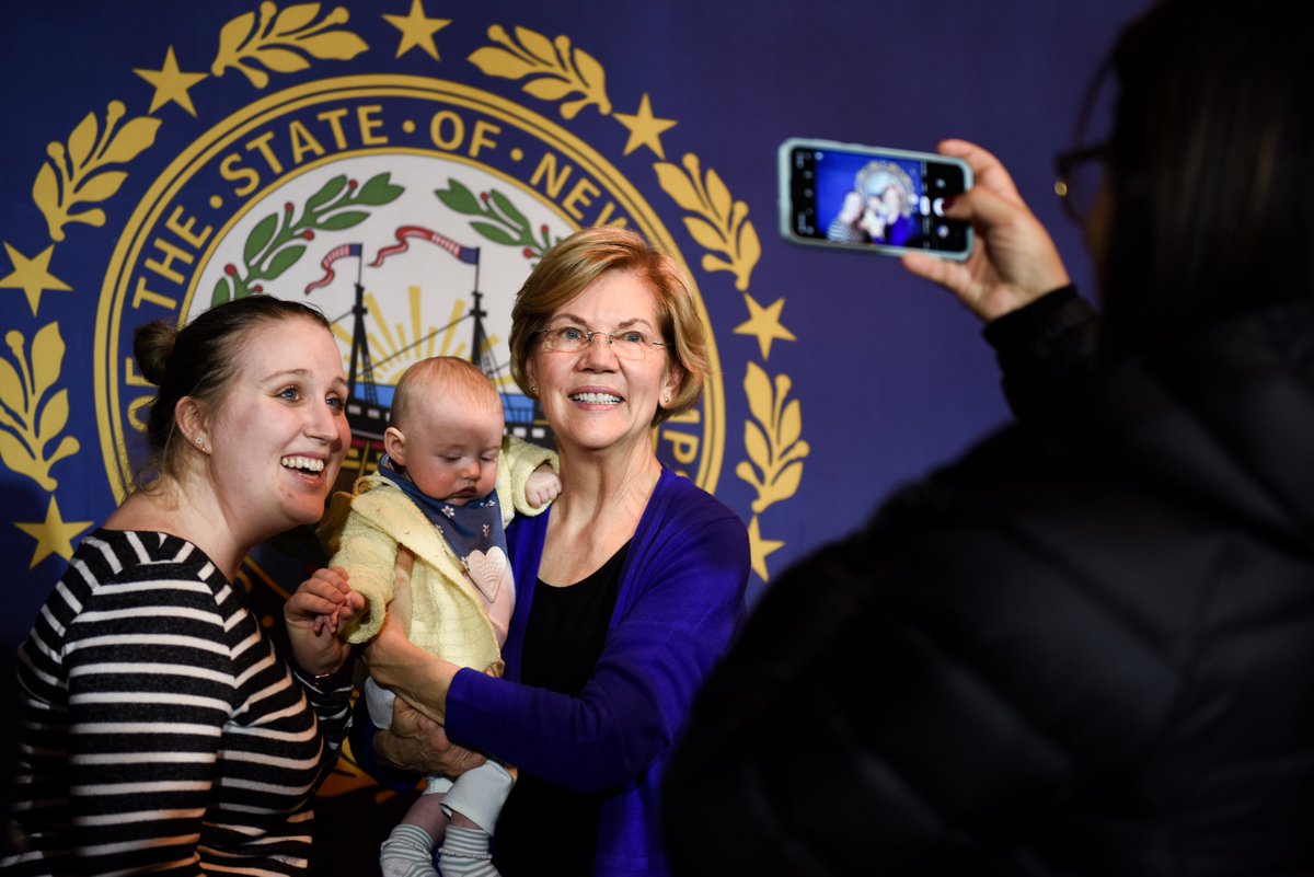 Elizabeth Warren takes a photo with a supporter and a baby at the Dover town hall.