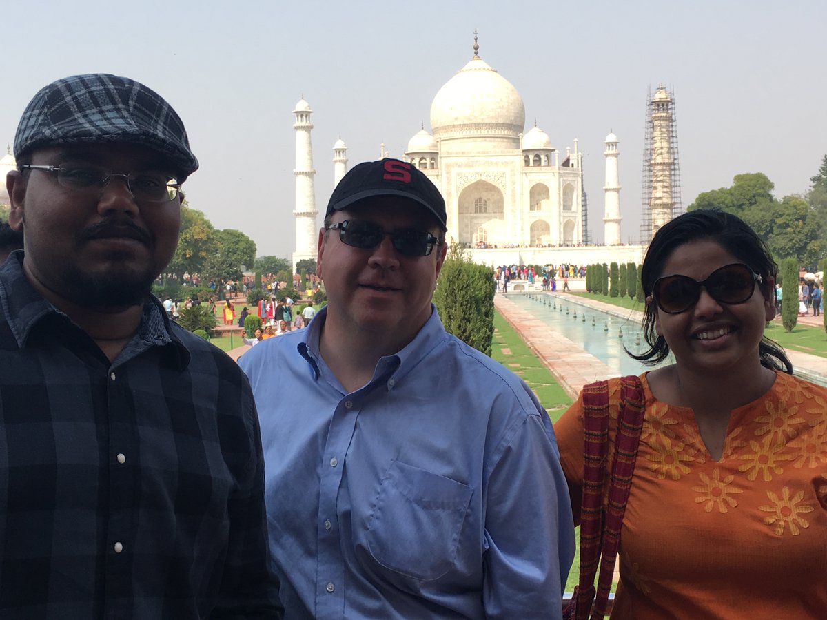Three people standing in front of the Taj Mahal