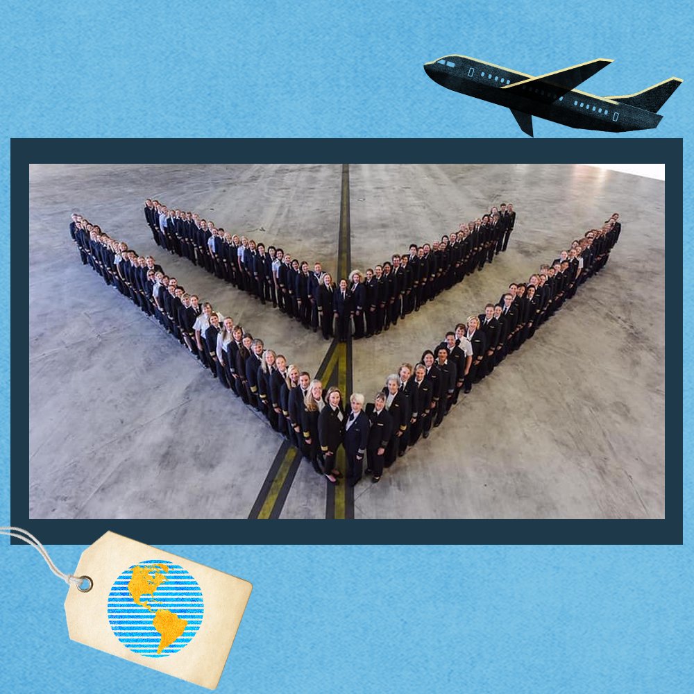 Photo of Female Pilots all standing in two v's in an airplane hanger. Photo is in front of a blue background with a yellow and blue glove on a tag