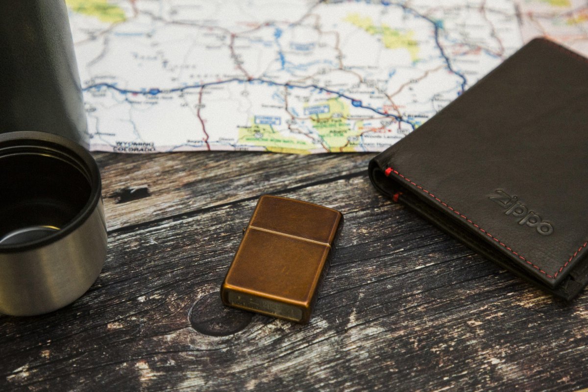 A Toffee Zippo lighter lies on a table next to a map of roadways.