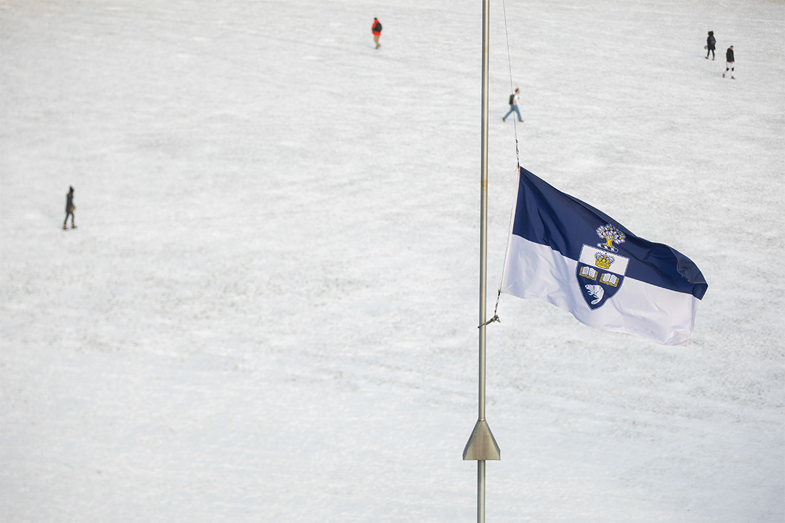 The U of T flag is shown lowered to half mast.
