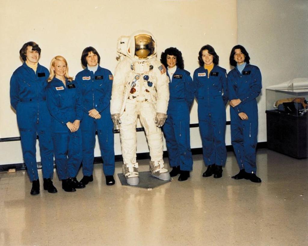 Shannon Lucid, Rhea Seddon, Kathryn Sullivan, Judith Resnik, Anna Fisher & Sally Ride pose with a spacesuit