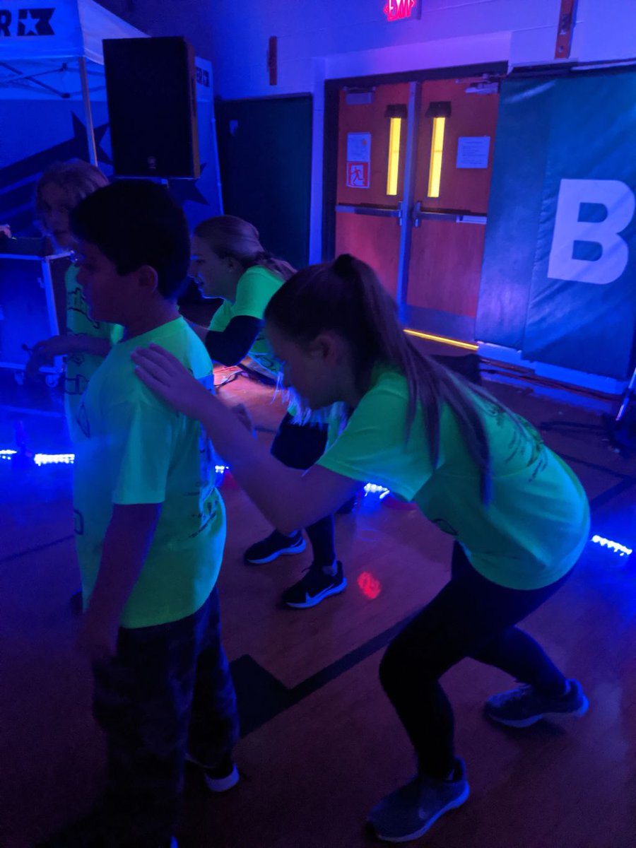 Eighth grade peer leaders helping the fourth graders mark laps during the glow run.