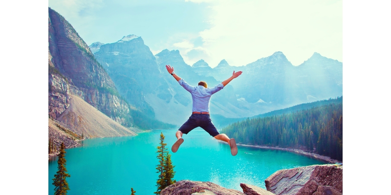 Man jumping into turquoise mountain lake