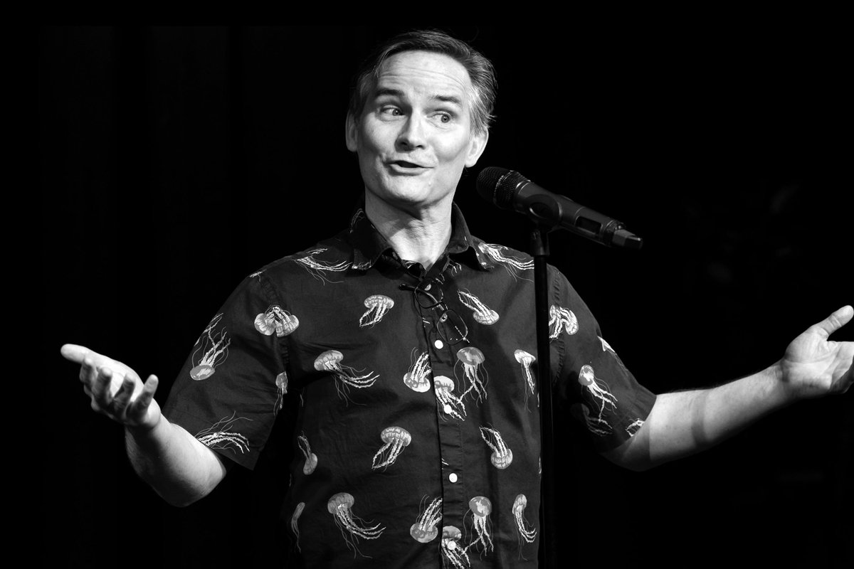 Photo of John Rennie telling his story at the microphone