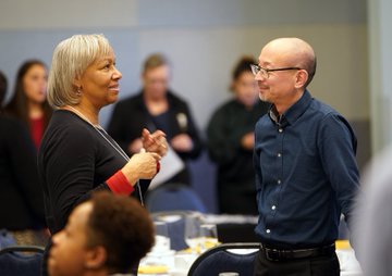 Two conference attendees engage in conversation